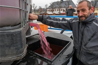 Eisarena im Erzgebirge öffnet - aber Ungewissheit bleibt - Mit mehr als 4000 Litern Kältemittel haben Sebastian Hähnel und seine Kollegen die Rohre der Eisbahn befüllt. Nun muss alle dreieinhalb Stunden Schicht für Schicht Wasser aufgetragen werden. Betreiber Andreas Engert (im Hintergrund) macht dafür wieder die Nacht zum Tag, schläft in seinem Transporter auf dem Markt.
