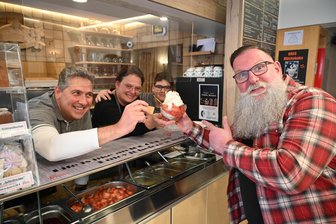 Eiscafé in Oederan startet in die 119. Saison: Volles Haus, auch wenn es draußen noch kühl ist - Kai Flößner ordert bei Katja Leonhardt, Enrico Liebing und Junior Marcus einen Erdbeer-Eisbecher.