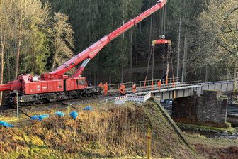 Eisenbahnbrücke im Pockautal wieder komplett - Ein Eisenbahnkran der Deutschen Bahn aus Leipzig hebt den zweiten Brückenteil auf die Auflager.