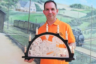 Eisenbahnfreunde versteigern Unikat - Vereinsvorsitzender Markus Nestler mit dem Schwibbogen, der auf der Facebookseite der Stadt Thum ersteigert werden kann. Die vorherige 13. Auktion, in der es um das Ausrichten eines Kindergeburtstags durch das Freizeit- und Familienzentrum Thum ging, entschied eine Bieterin mit einem Gebot von 130 Euro für sich.