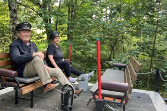 Eisenbahnromantik im Chemnitztal: Draisinefahrten am Radweg - Kerstin Strenske und ihr Mann treten in Eisenbahner-Look in die Pedale der Draisine. Ansonsten bieten sie am Imbiss Getränke und Essen an, darunter Gegrilltes und selbst gebackenen Kuchen.