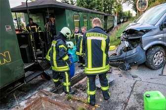Eisenbahnunfall im Erzgebirge: Sachschaden bei Kollision von Kleinbus mit Fichtelbergbahn - Feuerwehrleute an der Unfallstelle in Sehmataler Ortsteil Neudorf. An einem unbeschrankten Bahnübergang war am späten Samstagnachmittag ein VW-Kleinbus mit einem Zug der Fichtelbergbahn zusammengestoßen.