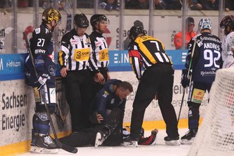 Eishockey-Referee verletzt sich bei Spiel in Dresden: Wie Linienrichter Marcus Höfer aus Crimmitschau die Situation erlebt hat - Linienrichter Marcus Höfer (links hinten) verfolgt die Behandlung von Hauptschiedsrichter Daniel Todam (auf dem Eis).