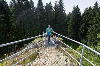 Eiszeit und Vulkanen auf der Spur - Geoparks locken Besucher - Dennis Loos, Geschäftsführer des Projekts Geo-Umweltpark Projekts "Sagenhaftes Vogtland", steht auf dem Schneckenstein, dem größten Topasfelsen Europas. Der etwa 23 Meter hohe Felsen im Vogtland wird auch als "Sächsischer Diamant" bezeichnet.