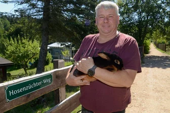 Ellefelder "Hosenzüchter" haben jetzt ihren eigenen Weg - Ab sofort gibt es im Ellefelder Ortsteil Hohofen den "Hosenzüchter-Weg". Der Vereinsvorsitzende Heiko Trommer hat sich fürs Foto ein Lohkaninchen schwarz von Roland Endler ausgeliehen.