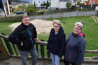 Elterlein sammelt Spenden für neuen Spielplatz - Toni Kehrer, Annette Ficker und Sandra Sywall auf dem Spielplatz in Elterlein. Im Hintergrund sieht man die Fläche, wo ein neues Spielgerät gebaut werden soll.