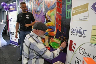 Emotionaler Moment: Schwarzenberger Künstler signiert sein Bild - Rico Weißflog signiert vor den Gästen des Fitnessstudios sein Bild. Für ihn ein emotionaler Moment.