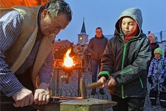 Endlich wieder Weihnachtsmarkt: Eine besondere Lichterfahrt durch das Weihnachtsland - Frauenstein war am Wochenende gefragtes Besuchsziel. Dicht umringt waren die Schmiede des Hammervereins der Region. Elia, 10 Jahre, aus Dresden versucht sich als Schmiedegeselle und schmiedete mit Volker Niese ein Eisenstück. 