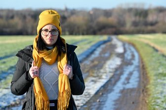 Endometriose: Wenn der Schmerz im Unterleib nicht aufhört - Peggy Herold hat schwere Zeiten hinter sich. Doch sie gibt nicht auf, kämpft gegen ihre Krankheit und hilft mit der Gründung einer Selbsthilfegruppe anderen Frauen. Sie trägt Gelb, da die Farbe für Endometriose steht. Zudem hat sie einen Wärmflaschen-Gürtel um, der ihren Körper warm hält.