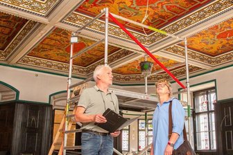 Endspurt auf der Langzeit-Baustelle - Architekt Uwe Kretzer und Bauamtsleiterin Petra Wolf im Ratssaal im Oederaner Rathaus. Die Deckenbemalung muss ausgebessert werden. Der Erker im Hintergrund wird mit einer Glasscheibe abgetrennt.
