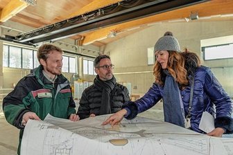 Endspurt in Bad Reiboldsgrün: Forstschule im Sommer fertig - Heike Krenkel, Leiterin der Sib-Niederlassung Zwickau (rechts), beim Termin mit dem Landtagsabgeordneten Sören Voigt (CDU) und Toni Eßbach, Leiter der Ausbildungsstätte, in der Maschinenhalle für die Forsttechnik.