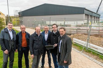 Energieminister Günther auf Stippvisite in Drebach - Sachsens Umweltminister Wolfram Günther (3. v. l.) mit Bürgerenergie-Vertretern Alexander Lohschmidt, Steffen Lötzsch, Volker Weber, Thomas Walther und Drebachs Bürgermeister Jens Haustein (v. l.) vor dem Neubau der Sporthalle in Drebach. 