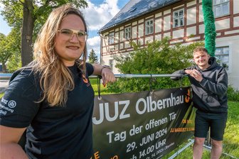 Engagiert im Erzgebirge: Wo junge Leute eine alte Schule in Schuss halten - Cheyenne Worotnik und Robin Pahner haben in Vorbereitung des Tages der offenen Tür unter anderem vor dem Jugendzentrum im Olbernhauer Ortsteil Kleinneuschönberg ein Banner aufgehängt.