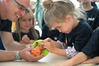 Entdeckertag mit der Maus in Freiberg: Welche Schätze ein ausgedientes Smartphone in sich trägt - Institutsdirektor Professor Jens Gutzmer und die fünfjährige Leonora aus Freiberg schrauben eine Maus-Lampe auseinander. Sie wollen das Innenleben der Lampe erkunden.