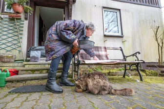 Enteignung wie in Lützerath? Was die Rechtsaufsicht gegen den Alm-Terror in Klingenthal tun will - Das Leben auf der terrorisierten Alm in Klingenthal. Anita Hochmuth füttert die Katze, die im Nachbarhaus lebt. Die letzte Bewohnerin ist gestorben, die Erben können das Haus wegen des Streits weder sanieren noch verkaufen.