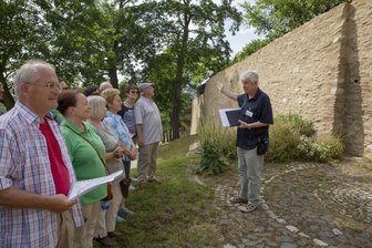 „Entlang der Stadtmauer“: Besondere Stadtführung im Erzgebirge - Unter Leitung von Klaus-Peter Herschel (r.) erkunden die Teilnehmenden die Überreste der historischen Stadtbefestigung.