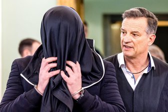 "Er fuhr einfach weiter": Mann für Polizisten-Tod verurteilt - Der Angeklagte kam mit einer Jacke über dem Kopf in den Gerichtssaal.