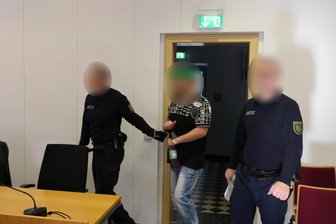 „Er kommt nicht mehr davon“: Wie ein Mann seine Entführung in Waldheim schildert - Der Hauptangeklagte wird in Handschellen in den Sitzungssaal des Landgerichts Chemnitz geführt. Ihm wird erpresserischer Menschenraub vorgeworfen.