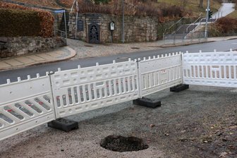 Erdloch tut sich in Stadt im Erzgebirge auf: Oberbergamt zur Ursachenklärung vor Ort - Dort, wo sich die Erde an der Schönheider Straße in Eibenstock aufgetan hat, klafft noch das Loch, und der Bereich ist abgesperrt. Gegenüber liegt der „Reue Glück Stolln“.
