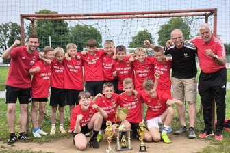 Erfolgreicher Langenauer Nachwuchscoach mit Kritik am System: „Ich hoffe, dass Fußballmannschaften daran nicht zerbrechen“ - Die D-Junioren von Fortuna Langenau feiern zusammen mit ihren Trainern die drei gewonnenen Trophäen.