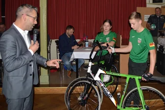 Erfolgreiches Radball-Duo plaudert mit Wechselburger Bürgermeister - Am Freitagabend demonstrierten Carl Mehnert (r.) und Leonie Reinicke ihr Können bei der Dankeschönveranstaltung im Wechselburger Schützenhaus. Auch Bürgermeister Daniel Bergert (l.) traute sich aufs Rad. Einen Tag später war das Duo wieder erfolgreich.