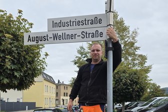 Erinnerung an einen legendären Besteck-Hersteller: Industriestraße in Aue erhält neuen Namen - Tobias Baumgarten vom städtischen Betriebshof bringt das neue Straßenschild an.