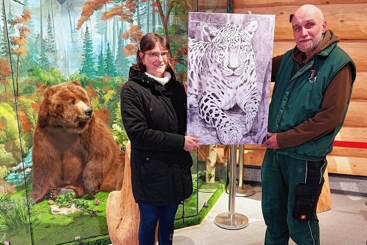 Erinnerung an Leopard: Tierpark erhält XL-Porträt - Hobbymalerin Steffi Sandner und Tierparkchef Tino Richter mit dem Porträt des Leoparden Assir, der über 20 Jahre eine Attraktion im Tierpark Klingenthal war - wie auch Grizzly-Dame Ulla.