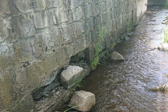 Erlbach: Ufermauern am Schwarzbach bröckeln - Die Mauer des Schwarzbachs oberhalb des ehemaligen Gemeindeamtes Erlbach bröckelt.