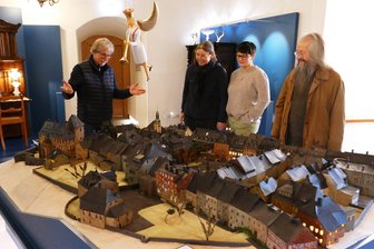 Erste Einblicke: So beeindruckend soll die neue Ausstellung im Schloss Wolkenstein werden - Kurator Jochen Voigt, Museumsleiterin Uta Liebing, Museologin Sandra Dürschmied und Bürgermeister Wolfram Liebing (von links) schauen sich im Turmsaal das Modell von Wolkenstein an.