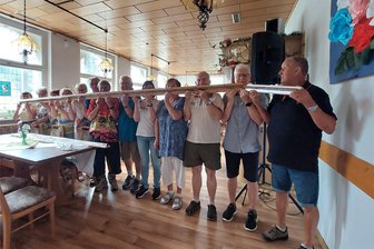Erste Probe auf Riesen-Mundharmonika im Vogtland: Bei vier Metern soll noch lange nicht Schluss sein - Zwölf Mitglieder der Klingenthaler Mundharmonika-Uhus probten am Mittwoch erstmals auf einer vier Meter langen Mundharmonika. Rechts im Foto: Leiter Jürgen Just mit einem Sondermodell. Der erste Auftritt soll am 7. August sein.