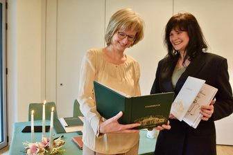 Erste Trauung im März geplant: Wo in Limbach-Oberfrohna bald geheiratet werden kann - Die Standesbeamtinnen Silvia Nahlovsky (li.) und Christine Roßmann mit dem Stammbuch samt neuer Hippodrom-Prägung.