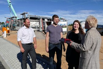 Erstes Richtfest in neuem Gornauer Wohngebiet gefeiert - Schon vor dem Richtfest durften sich Daniela Immer und Björn Lang über die Glückwünsche von Gornaus Bürgermeister Nico Wollnitzke (l.) und Roger Krause (r.), dem Geschäftsführer der IDC Immobilien Development GmbH, freuen.