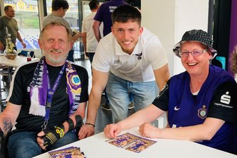 Erzgebirge Aue: Was FCE-Fans mit Handicap im Erzgebirgsstadion loben und was sie sich wünschen - Veilchen-Kicker Linus Rosenlöcher (M.) begeisterte beim Fan-Stammtisch für Aue-Fans mit Handicap mit seiner lockeren und offenen Art. Bodo Meisel und Mandy Kramp sicherten sich Autogramme und Erinnerungsfoto.