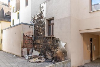 Erzgebirge: Brennende Mülltonnen beschädigen Häuserwand massiv - Ein schwerer Schaden ist durch einen Mülltonnenbrand in Stollberg entstanden: Die Polizei ermittelt zur Brandursache.