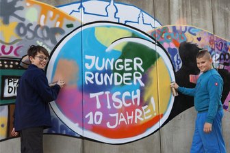Erzgebirge: Großes Graffiti ziert Mauer am Kätplatz und weist auf besonderes Jubiläum hin - Juha (l.) und Kurt bei den letzten Arbeiten am neuen Graffiti auf dem Kätplatz an der B 95.
