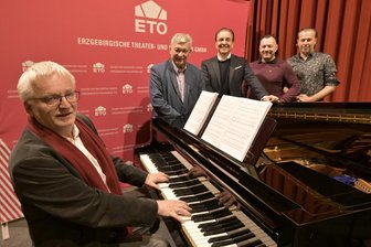 Erzgebirge lädt zum großen Philharmonieball – Musik, Masken und Sternekoch inklusive - Ekkehard Klemm (am Flügel) dirigiert die Erzgebirgische Philharmonie zum 14. Philharmonieball. Auf den freuen sich auch OB Heinrich Kohl, Intendant Moritz Gogg, Sterne-Koch Benjamin Unger und Alexander Fuchs von der Iga Westerzgebirge (hinten von links).