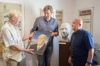 Erzgebirge: Museum soll Bildnis von einstigem Thomaskantor bekommen - Konrad Lepetit, Bürgermeister André Rösch und Christian Günther im Mauersberger-Museum mit einem Bild des ehemaligen Kreuzkantors Rudolf Mauersberger.