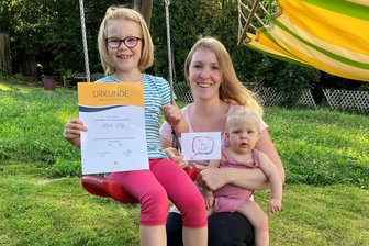 Erzgebirge: Siebenjährige spendet ihre Haare für ein krankes Kind - Haarspenderin Merle mit ihrer Mutter und Stiefschwester Fenia. In der Hand hält sie eine Urkunde, die sie vom Perückenstudio für ihre Spende bekam.