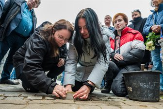 Erzgebirge: Stadt Aue-Bad Schlema lässt elf Jahre zurückgehaltenen Stolperstein verlegen - Der sechste Stolperstein kommt ins Pflaster: Verlegt haben ihn Nathalie Tuchscheerer, Anna-Sophie Seifert und Cedric Luber (v. l.), Azubis am Institut für Ausbildung Jugendlicher Aue.