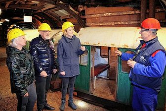 Erzgebirge: Ukrainische Gewerkschafter fahren ins Bergwerk Pöhla ein - Vor der Einfahrt mit der Grubenbahn ins Besucherbergwerk Zinnkammern Pöhla bekamen die ukrainischen Gewerkschafter Maryna Samojlova und Jurij Samojlov sowie die Bundestagsabgeordnete der Linken, Clara Bünger, von Bergführer Andreas Obst (v. l.) noch einige Erläuterungen.