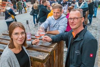 Erzgebirger sind in Feierlaune - Hotelier Markus Gorny (r.) stieß zu Beginn des Weinfestes am Freitagabend mit den Winzern Philipp und Stephanie Hof an. Die beiden Pfälzer beteiligten sich schon mehrfach an der Veranstaltung in der Saigerhütte.