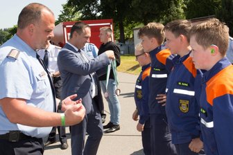 Erzgebirger spenden, Sparkasse rundet auf: Geldsegen für die Jugendarbeit der Feuerwehren in der Region - Regionalbereichsleiter Michael Schönherr (l.) vor einer Jugendvertretung der Zöblitzer Wehr.