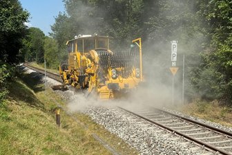 Erzgebirgsbahn tauscht potenziell gefährliche Schwellen aus - Nachdem Schwellen ausgetauscht und der Schotter gestopft wurde, profiliert die Schotterplaniermaschine zum Abschluss der Arbeiten den Gleiskörper, hier in der Ortslage Blumenau.