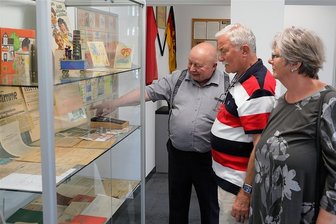 Erzgebirgssparkasse bietet in Schwarzenberg Geschichte zum Anfassen - In der sparkassenhistorischen Ausstellung erzählt Horst Möckel (l.) Wolfgang und Birgit Weigel aus Bernsbach Anekdoten zum DDR-Geld. 
