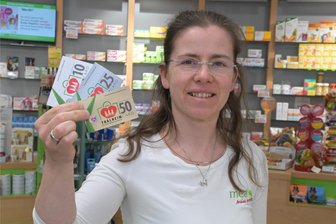 Erzgebirgsstadt fällt Entscheidung über Gutscheine – So viele werden gar nicht eingelöst - Franziska Wagner von der Apotheke am Rathaus zeigt Thalheim-Cards – ein städtisches Gutscheinsystem.
