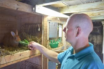 Es hoppelt in Pleißa: Hunderte Tiere zur Kaninchenschau erwartet - Vereinsmitglied Matthias Heidrich beim Füttern eines Kleinsilbers gelb.