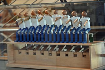 „Es sind Mitmenschen“: Kunst im Knast - ein seltener Blick hinter Gefängnismauern in Oederan - In der Sonderschau im Museum am Markt Oederan zu sehen: La Ola-Welle heißt die Konstruktion, bei der sich alle Figuren rhythmisch bewegen, wird eine Figur bewegt.
