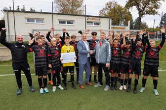 ESV Lok Plauen: Wie können Jugendliche dem Fußball erhalten bleiben? - Der Nachwuchs von Lok Plauen freuen sich über einen Scheck über 1000 Euro, den C-Jugend-Trainer Pascal Mann (Mitte, rechts) von Thomas Bär (SBG Neumark, links daneben) entgegennahm. Der Verein tut viel, um seine Kinder und Jugendlichen zu halten.