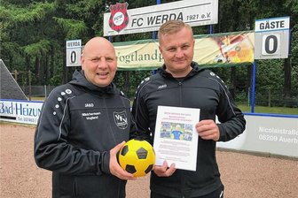 Etiennes Kampf gegen den Tumor: Elfjähriger bekommt auch von Fußball-Kollegen Unterstützung - Ein Fußball als Spendenbox: André Rabe vom Vogtländischen Fußballverband (links) und Vereinschef Denny Pommer vom ausrichtenden FC Werda hoffen, dass am Wochenende viel Geld für die Aktion „Als Team für Etienne“ zusammenkommt.