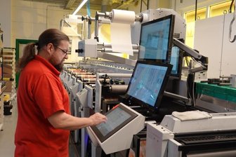 Etiketten für die ganze Welt - Enrico Herzog bedient die moderne Flexodruckmaschine, an der für das Trocknen der einzelnen Farben energiesparende LED-Technik angewendet wird.